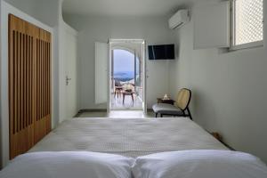 a bedroom with a bed and a view of the ocean at Aethria Villa in Imerovigli +84 photos