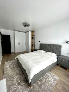 una camera con un grande letto e una parete bianca di Apartament central 2 camere a Râmnicu Vâlcea