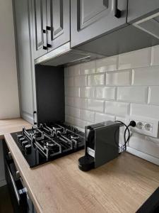 a kitchen counter with a stove and a microwave at Apartament central 2 camere in Râmnicu Vâlcea