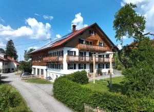 a large wooden house with a balcony on a road at Alpenloft Mereine in Oy-Mittelberg