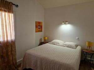 een slaapkamer met een wit bed en een raam bij Villas Abbartello in Olmeto