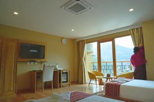 a hotel room with two beds and a television at Cholay Khangzang in Thimphu