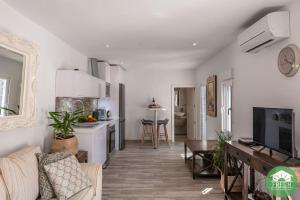 ein Wohnzimmer mit einem Sofa und einer Küche in der Unterkunft Town house with roof terrace in heart of Vinuela in Viñuela