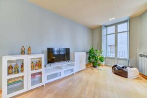 uma sala de estar com um centro de entretenimento branco com uma televisão em Apartamento El Rincón del Chupinazo em Pamplona