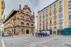 um grupo de pessoas em pé em frente a um edifício em Apartamento El Rincón del Chupinazo em Pamplona