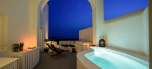 a large bath tub in a room with a blue light at Aethria Villa in Imerovigli