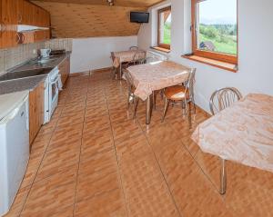 uma cozinha com pisos em madeira, uma mesa e cadeiras em Dom na okraji obce - Privát Šiškovci em Habovka