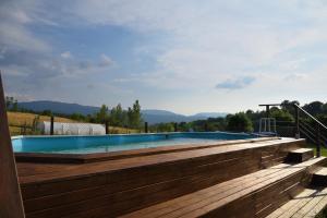 a large swimming pool with a wooden deck at Il Fienile di Margherita in Vicchio