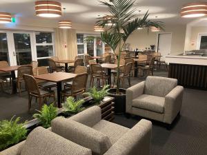 un restaurant avec des tables, des chaises, des tables et des plantes dans l'établissement Newina Rotorua, à Rotorua