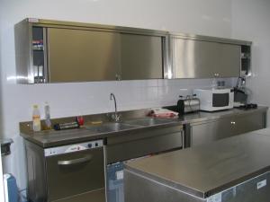 eine Küche mit einer Spüle und einer Mikrowelle in der Unterkunft Le presbytere in Douzy