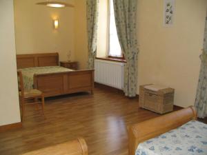 1 Schlafzimmer mit 2 Betten, einem Fenster und Holzböden in der Unterkunft Le presbytere in Douzy