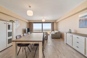 eine Küche und ein Esszimmer mit Tisch und Stühlen in der Unterkunft Ster der Zee - zeedijk app voor 6pers met zeezicht in Middelkerke