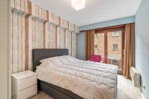 ein Schlafzimmer mit einem Bett und einem Fenster in der Unterkunft Ster der Zee - zeedijk app voor 6pers met zeezicht in Middelkerke