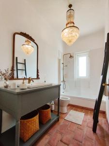 W łazience znajduje się umywalka, lustro i toaleta. w obiekcie Alecrim d'Aldeia w mieście Fronteira