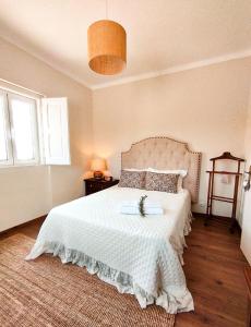 1 dormitorio con 1 cama grande con colcha blanca en Alecrim d'Aldeia en Fronteira