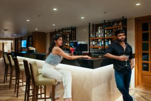 a man and a woman standing at a bar at Fairfield by Marriott Goa Calangute in Calangute