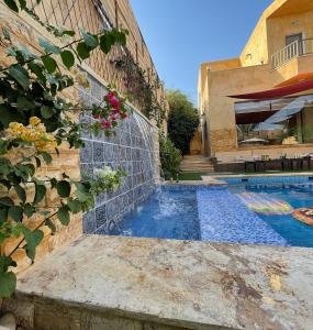 a villa with a swimming pool and a house at Orient Villa-Dead Sea in Sowayma