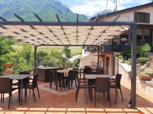 eine Terrasse mit Tischen und Stühlen unter einer Pergola in der Unterkunft Nel cuore della maiella in Palombaro