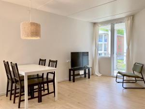 a dining room with a table and chairs and a tv at Newly Renovated Two Bedroom Apartment In City Center Of Herning in Herning