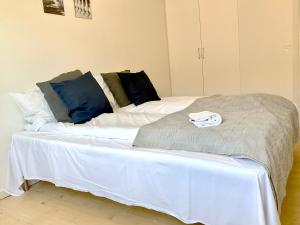 1 cama grande con sábanas blancas y almohadas azules en Newly Renovated Two Bedroom Apartment In City Center Of Herning, en Herning