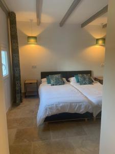 een slaapkamer met 2 bedden met witte lakens en blauwe kussens bij Provencelia in Pernes-les-Fontaines
