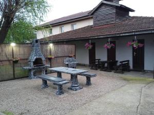 a backyard with a picnic table and a grill at Markaz Apartman Bihac in Bihać