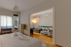 a white bedroom with a bed and a living room at Victoria metro st. 1 bedroom 4 persons by MPS in Athens