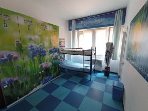 Cette chambre comprend un lit et une fresque murale fleurie. dans l'établissement Milano Ostello, à Milan