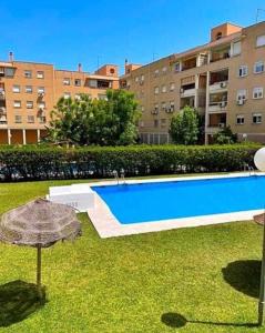uma piscina num quintal com um guarda-chuva em Piso en zona teatinos by Centric em Málaga