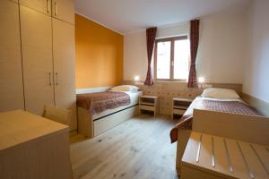 Ribnica na PohorjuにあるLake Peak Apartments, Ribniško Pohorjeのベッド2台と窓が備わる小さな客室です。