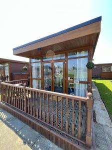 a house with a balcony with glass doors at Cozzzy Seaside Retreat in Mablethorpe
