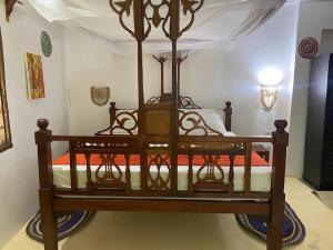 a large wooden bed in a room at Kingstone lodge zanzibar in Bet-el-Mali
