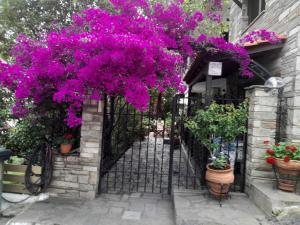 a black iron gate with purple flowers on it at Papatzikos Traditional Guesthouse in Neos Marmaras