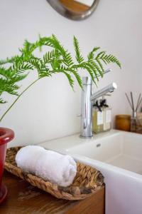 - Baño con lavabo y cesta con toallas en Valle de Bravo Casa Santa Rosa en Valle de Bravo