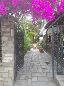 a fence with pink flowers on top of it at Papatzikos Traditional Guesthouse in Neos Marmaras