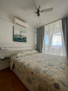 a bedroom with a bed and a large window at Apartmani Mira Sumić in Podgora