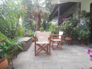 a patio with chairs and potted plants in a house at Papatzikos Traditional Guesthouse in Neos Marmaras