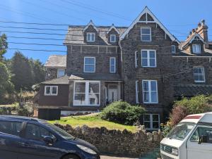 a large stone house with cars parked in front of it at Fernworthy in Okehampton