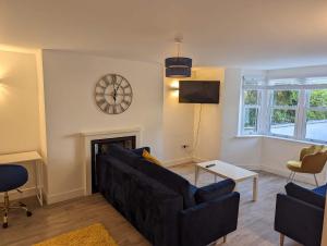 a living room with a couch and a clock on the wall at Fernworthy in Okehampton