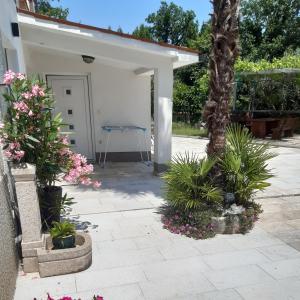 a patio with a table and some plants at Apartman Nevia lka in Opric