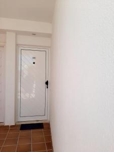 テギセにあるLos Naranjos Iのタイルフロアの客室内の白いドア