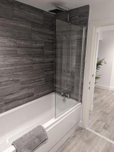 a bathroom with a tub and a glass shower at Fernworthy in Okehampton