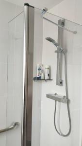 a bathroom with a shower with a shower head at Linksway House in Birkenhead