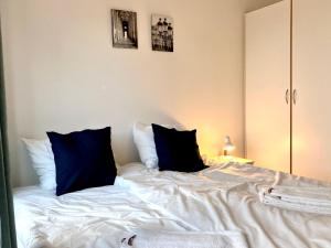 a white bed with blue pillows on top of it at Cosy 1-bedroom Apartment In Herning in Herning