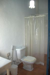uma casa de banho com um WC branco e um chuveiro em FAZENDAS ANTIGAS HOTEL em Sumidouro