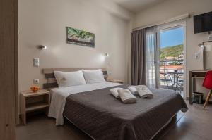 1 dormitorio con 1 cama grande y balcón en Sunshine Apartments en Neos Marmaras