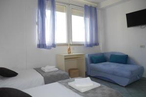 - une chambre avec un lit, un canapé bleu et une fenêtre dans l'établissement Apartment in Dugi Rat with sea view, balcony, air conditioning WiFi 5132-1, à Dugi Rat