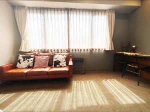 a living room with a couch in front of a window at HOTEL SUI AKASAKA by ABEST in Tokyo