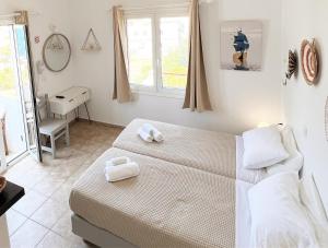 a bedroom with a bed with two towels on it at Anna Studios in Katapola