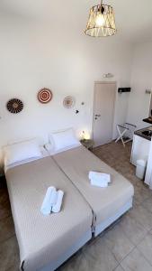 a bedroom with a large bed with towels on it at Anna Studios in Katapola